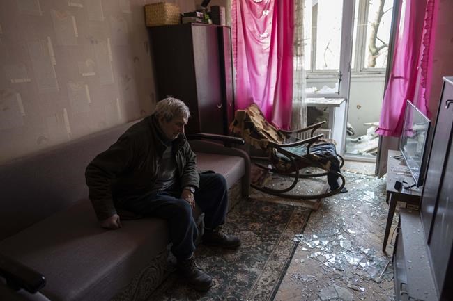Volodymyr, 80, rests inside his apartment damaged by shelling, in Kyiv, Ukraine,Wednesday, March 23, 2022. (AP Photo/Rodrigo Abd)