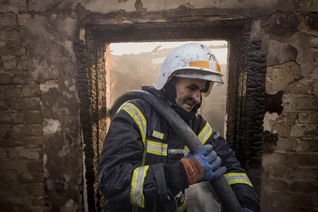 Ukrainian firefighters spray water inside a house destroyed by bombing in Kyiv, Ukraine, Wednesday, March 23, 2022. The Kyiv city administration says Russian forces shelled the Ukrainian capital overnight and early Wednesday morning, in the districts of Sviatoshynskyi and Shevchenkivskyi, damaging buildings. (AP Photo/Vadim Ghirda)