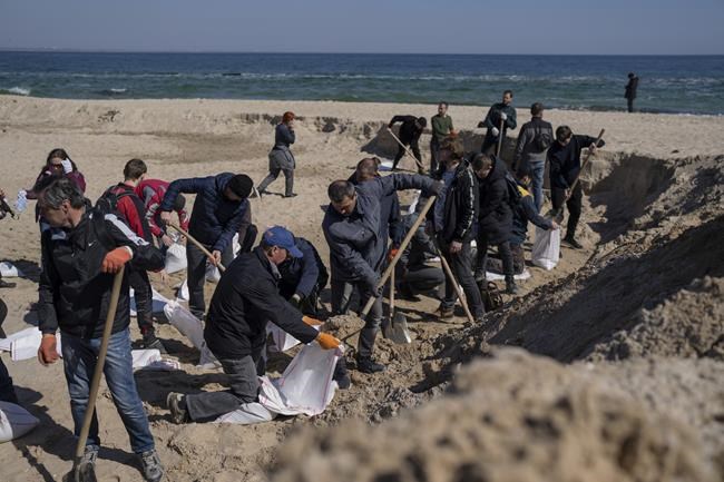 Volunteers at a sand beach fill sandbags to defend their city, in Odesa, southern Ukraine, on Wednesday, March 23, 2022. Western officials say that Ukrainian resistance has halted much of Russia's advance. (AP Photo/Petros Giannakouris)
