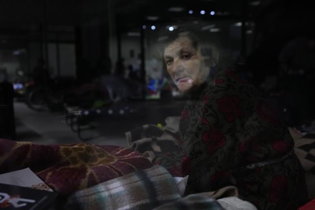 A Ukrainian woman sits on a bed at an exhibition hall, turned into a refugee center in Nadarzyn, near Warsaw, Poland, on Wednesday, March 23, 2022. The United Nations says more than 3.5 million people — mainly women and children — have fled Ukraine in the four weeks since Russian tanks rolled across the border and Moscow began bombarding towns and cities. (AP Photo/Petr David Josek)