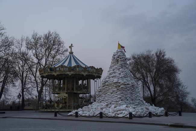 The monument of the Duke of Richelieu, is covered with sandbags next to a Carrousel , in Odesa, Ukraine, Thursday March 24, 2022. The city of Odesa is prepared for a possible Russian offensive. (AP Photo/Petros Giannakouris)