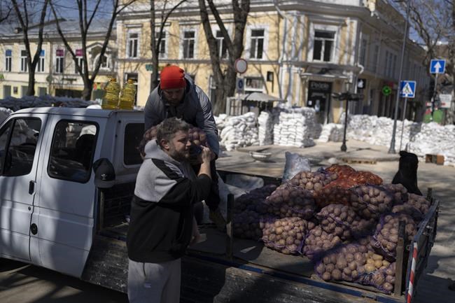 Volunteers load a truck with potatoes in Odesa, on Thursday, March 24, 2022. (AP Photo/Petros Giannakouris)