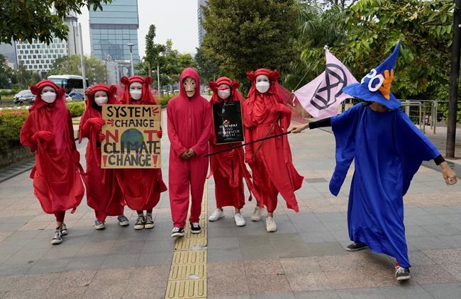 Environmental activists hold up posters during a protest calling for the government to take immediate action against climate change in Jakarta, Indonesia, Friday, March 25, 2022. (AP Photo/Tatan Syuflana)