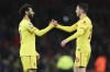 Liverpool's Mohamed Salah, left, and teammate Andrew Robertson celebrate after the English Premier League soccer match between Arsenal and Liverpool at Emirates Stadium in London, Wednesday, March 16, 2022. (AP Photo/Ian Walton)