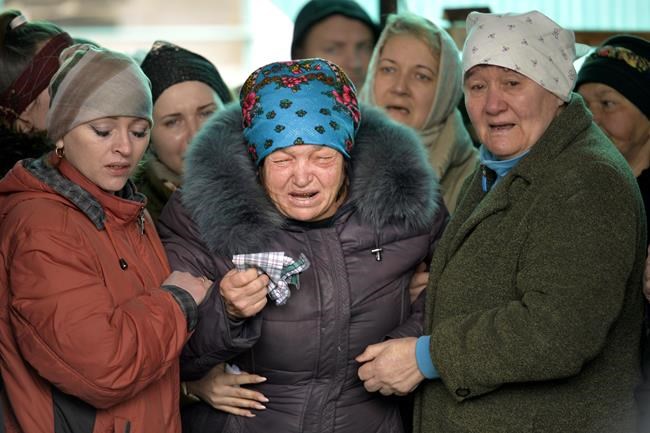 The mother of Russian Army soldier Rustam Zarifulin, who was killed fighting in Ukraine, center, cries surrounded by relatives during a farewell ceremony in his homeland in Kara-Balta, 60 km (37 miles) west of Bishkek, Kyrgyzstan, Sunday, March 27, 2022. (AP Photo/Vladimir Voronin)