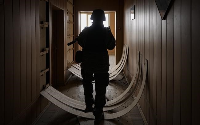 A Ukrainian serviceman walks in a heavily damaged building in Stoyanka, Ukraine, Sunday, March 27, 2022. Ukrainian President Volodymyr Zelenskyy accused the West of lacking courage as his country fights to stave off Russia's invading troops, making an exasperated plea for fighter jets and tanks to sustain a defense in a conflict that has ground into a war of attrition. (AP Photo/Vadim Ghirda)