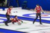 Team Canada skip Kerri Einarson throws a stone while lead Briane Meilleur, left, and second Shannon Birchard prepare to sweep in the bronze medal game against Team Sweden at CN Centre during the Women's World Curling in Prince George, B.C., on Sunday, March 27, 2022. THE CANADIAN PRESS/James Doyle