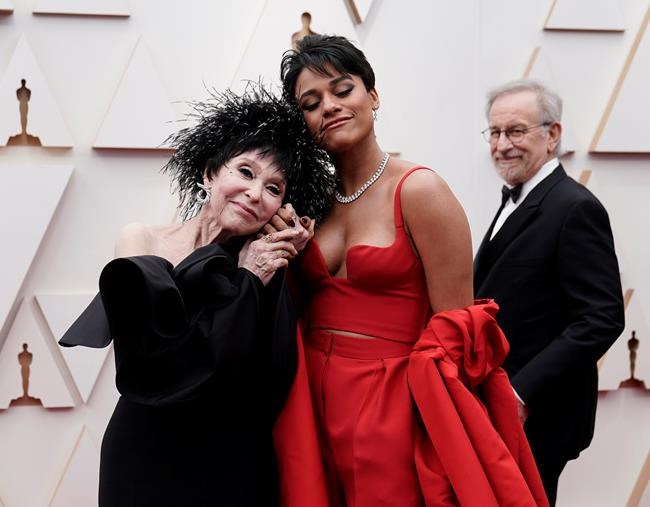 Rita Moreno, left, and Ariana DeBose arrive at the Oscars on Sunday, March 27, 2022, at the Dolby Theatre in Los Angeles. Looking in background is Steven Spielberg. (AP Photo/Jae C. Hong)