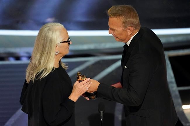 Kevin Costner, right, presents Jane Campion with the award for best director for