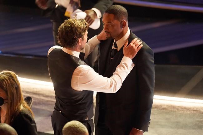 Bradley Cooper, left, and Will Smith appear in the audience at the Oscars on Sunday, March 27, 2022, at the Dolby Theatre in Los Angeles. (AP Photo/Chris Pizzello)