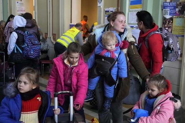 Ukrainian Marina Stadnik from Kramatosrk, waits with her four children at a train station in Przemysl, southeastern Poland, Monday, March 28, 2022. The more than month-old war has killed thousands and driven more than 10 million Ukrainians from their homes — including almost 4 million from their country. (AP Photo/Sergei Grits)