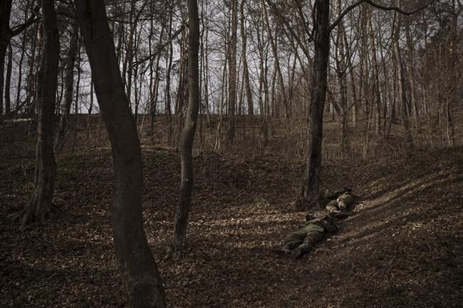 The bodies of two Russian soldiers are seen at the woods in Trostsyanets, Ukraine, Monday, March 28, 2022. Trostsyanets was recently retaken by Ukrainian forces after being held by Russians since the early days of the war. (AP Photo/Felipe Dana)