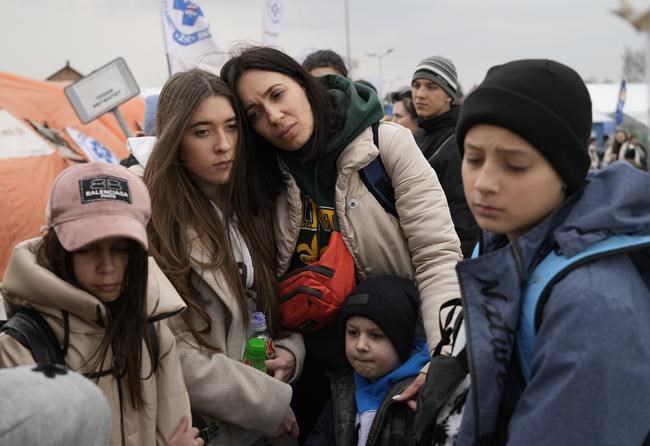 Refugees wait in a queue, after fleeing the war from neighbouring Ukraine at the border crossing in Medyka, southeastern Poland, on Tuesday, March 29, 2022. The daily number of people fleeing Ukraine has fallen in recent days but border guards, aid agencies and refugees say Russia's unpredictable war offers few signs whether it's just a temporary lull or a permanent drop-off. (AP Photo/Sergei Grits)