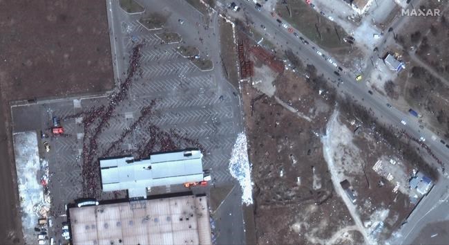 This satellite image provided by Maxar Technologies shows a crowd of people outside a grocery store in Mariupol, Ukraine, Tuesday, March 29, 2022. (Maxar Technologies via AP)