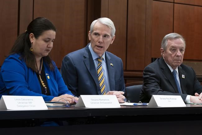 Sen. Rob Portman, R-Ohio, center, flanked by Ukrainian Amb. Oksana Markarova, left, and Sen. Dick Durbin, D-Ill., right, holds a meeting with members of the Senate Ukraine Caucus and members of the Ukrainian Parliament, at the Capitol in Washington, Wednesday, March 30, 2022. (AP Photo/J. Scott Applewhite)