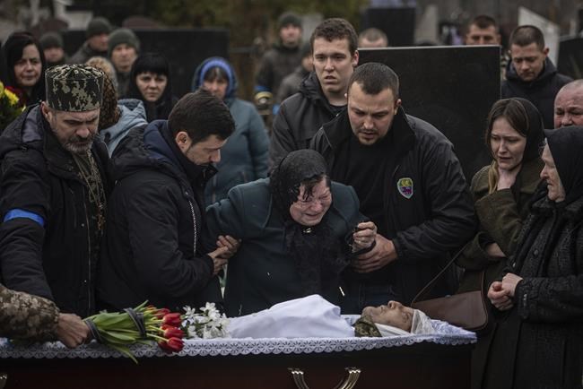 The mother of killed Ukrainian serviceman Georgiy Plisak cries during his funeral ceremony at a cemetery near Lutsk, Ukraine, Thursday, March 31, 2022. Russian troops handed control of the Chernobyl nuclear power plant back to the Ukrainians and left the heavily contaminated site early Friday, more than a month after taking it over, Ukrainian authorities said, as fighting raged on the outskirts of Kyiv and other fronts. (AP Photo/Evgeniy Maloletka)