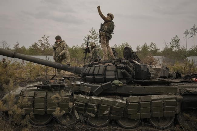 A Ukrainian serviceman takes a selfie photograph standing on a destroyed Russian tank after Ukrainian forces overran a Russian position outside Kyiv, Ukraine, Thursday, March 31, 2022. Heavy fighting raged on the outskirts of Kyiv and other zones Thursday amid indications the Kremlin is using talk of de-escalation as cover while regrouping and resupplying its forces and redeploying them for a stepped-up offensive in eastern Ukraine.(AP Photo/Vadim Ghirda)