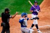 Colorado Rockies' Garrett Hampson, right, argues with umpire Nestor Ceja, left, after a called strike as Texas Rangers catcher Mitch Garver, center, throws the ball back to the pitcher during the fourth inning of a spring training baseball game Saturday, March 26, 2022, in Scottsdale, Ariz. (AP Photo/Ross D. Franklin)