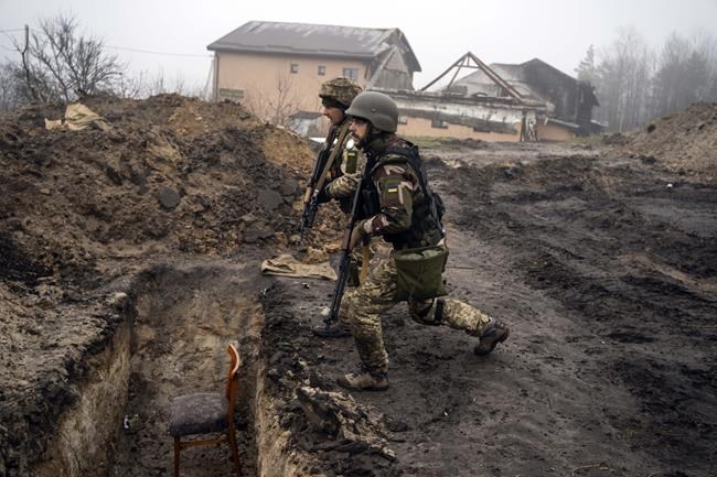 Ukrainian soldiers inspect trenches used by Russian soldiers during the occupation of villages on the outskirts of Kyiv, Ukraine, Friday, April 1, 2022. (AP Photo/Rodrigo Abd)