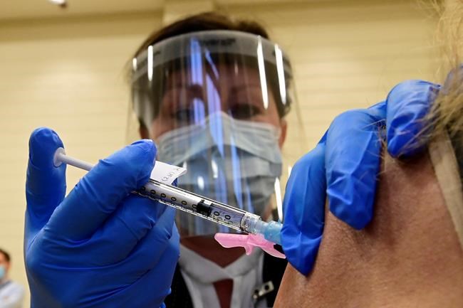 Tamara Dus, director of University Health Network Safety Services, administers a Pfizer-BioNTech COVID-19 vaccine in Toronto on Monday, Dec. 14, 2020. More Canadians may soon be offered a fourth dose of the COVID-19 vaccine. Canada's advisory panel on vaccines is expected to update its booster guidance in coming days as concern mounts over a possible sixth wave. THE CANADIAN PRESS/Frank Gunn