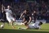Southampton's Che Adams, centre, is tackled by Leeds United's Diego Llorente, during the English Premier League soccer match between Leeds United and Southampton, at Elland Road, in Leeds, England, Saturday April 2, 2022. (Tim Goode/PA via AP)
