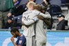 CF Montréal players embrace in front of FC Cincinnati defender Ray Gaddis, left, at the end of an MLS soccer match Saturday, April 2, 2022, in Cincinnati. CF Montréal won 4-3. (AP Photo/Jeff Dean)