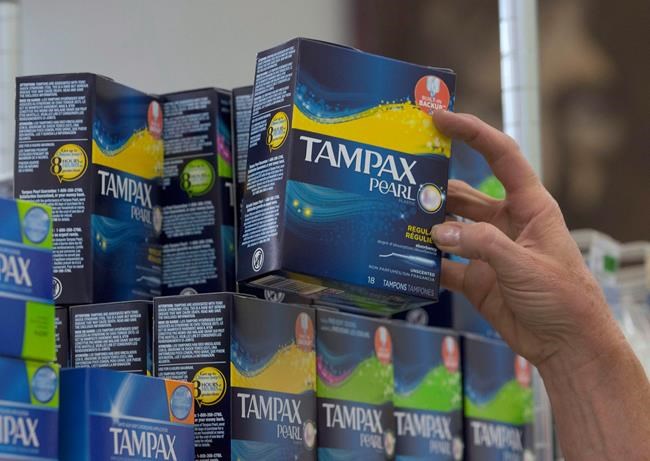 Tammy Compton restocks tampons at Compton's Market, Wednesday, June 22, 2016, in Sacramento, Calif. Advocates say that government should make menstrual products freely available for those who need them. NDP MP Leah Gazan, critic for women and gender equality, says they should be treated as an essential hygiene product, like toilet paper. (AP Photo/Rich Pedroncelli)