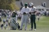 Rory McIlroy, of Northern Ireland, checks his course notes with his caddie on the first hole during a practice round for the Masters golf tournament on Monday, April 4, 2022, in Augusta, Ga. (AP Photo/Charlie Riedel)