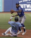 Kansas City Royals shortstop Adalberto Mondesi (27) holds the ball after forcing Seattle Mariners' Adam Frazier (26) out at second on a force out hit into by Jarred Kelenic during the third inning of a spring training baseball game Tuesday, March 29, 2022, in Peoria, Ariz. (AP Photo/Charlie Riedel)