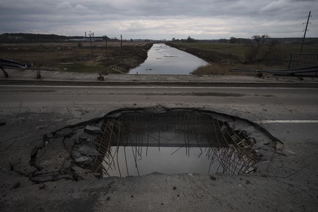 The Irpin river is seen through a damaged bridge in Bucha, on the outskirts of Kyiv, Ukraine, Wednesday, April 6, 2022. (AP Photo/Felipe Dana)