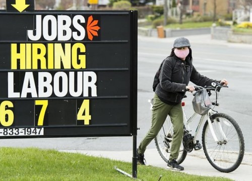 A woman checks out a jobs advertisement sign in Toronto on Wednesday, April 29, 2020. THE CANADIAN PRESS/Nathan Denette
