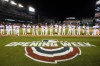 Members of the Washington Nationals wave as they stands on the first base line during pregame festivities in an opening day baseball game against the New York Mets at Nationals Park, Thursday, April 7, 2022, in Washington. (AP Photo/Alex Brandon)
