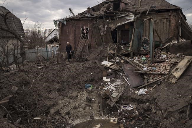 Oleg Mezhiritsky stands outside his house, damaged after a Russian attack in Kharkiv, Ukraine, Friday, April 8, 2022. (AP Photo/Felipe Dana)