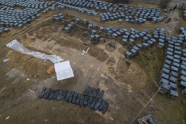 Plastic bags with corpses exhumed from a mass grave are lined up in Bucha, on the outskirts of Kyiv, Ukraine, Friday, April 8, 2022. (AP Photo/Rodrigo Abd)