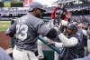 Washington Nationals designated hitter Nelson Cruz celebrates his solo home run with manager Dave Martinez during the first inning of a baseball game against the New York Mets at Nationals Park, Sunday, April 10, 2022, in Washington, D.C. (AP Photo/Alex Brandon)
