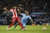 Manchester City's Raheem Sterling, right, is challenged by Atletico Madrid's Reinildo Mandava during the Champions League, first leg, quarterfinal soccer match between Manchester City and Atletico Madrid at the Etihad Stadium, in Manchester, Tuesday, April 5, 2022. (AP Photo/Dave Thompson)