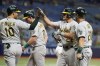 Oakland Athletics' Sheldon Neuse (26) celebrates with teammates, including Chad Pinder (10), Billy McKinney (28) and Stephen Vogt (21) after hitting a grand slam off Tampa Bay Rays' Brett Phillips during the ninth inning of a baseball game Monday, April 11, 2022, in St. Petersburg, Fla. (AP Photo/Chris O'Meara)
