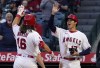 Los Angeles Angels' Brandon Marsh, left, is congratulated by Shohei Ohtani, right, and Max Stassi after hitting a three-run home run during the first inning of a baseball game Monday, April 11, 2022, in Anaheim, Calif. (AP Photo/Mark J. Terrill)