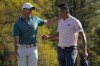 Rory McIlroy, of Northern Ireland, talks to Collin Morikawa after they both holed out from the bunker for a birdie during the final round at the Masters golf tournament on Sunday, April 10, 2022, in Augusta, Ga. (AP Photo/David J. Phillip)