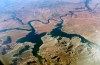 FILE - An aerial view of Lake Powell on the Colorado River along the Arizona-Utah border on Sept. 11, 2019. A dam holds back Lake Powell, one of the largest man-made reservoirs in the country. Federal officials sent seven western states a letter this week warning them that they're considering cutting the amount of water that flows through the Colorado River to the Southwest to maintain Lake Powell and prevent it from shrinking to a point at which Glen Canyon Dam could no longer produce hydropower. Consideration of what would be an unprecedented move comes sooner than water officials expected as they reckon with the effects drought and climate change have on their urban and agricultural customers. (AP Photo/John Antczak, FIle )