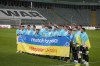 Team's players pose holding a banner before a friendly charity soccer match between Legia Warszawa and Dynamo Kyiv at the Polish Army Stadium in Warsaw, Poland, Tuesday, April 12, 2022. Ukrainian soccer club Dynamo Kyiv will play a series of charity games on a government-backed 