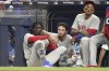 Philadelphia Phillies' Didi Gregorius, left, Garrett Stubbs, center, and Johan Camargo look on during the ninth inning of a baseball game against the Miami Marlins, Friday, April 15, 2022, in Miami. (AP Photo/Lynne Sladky)