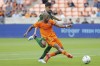 Houston Dynamo midfielder Fafà Picault, front, attempts a shot on goal in front of Portland Timbers defender José van Rankin, top, during the first half of an MLS soccer match Saturday, April 16, 2022, in Houston. (AP Photo/Michael Wyke)