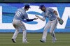 Kansas City Royals left fielder Andrew Benintendi (16) and right fielder Whit Merrifield (15) celebrate after their baseball game against the Detroit Tigers Saturday, April 16, 2022, in Kansas City, Mo. The Royals won 3-1. (AP Photo/Charlie Riedel)