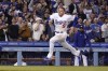 Los Angeles Dodgers' Freddie Freeman loses his helmet as gets ready to score on a double by Trea Turner during the fourth inning of a baseball game against the Atlanta Braves Monday, April 18, 2022, in Los Angeles. (AP Photo/Mark J. Terrill)