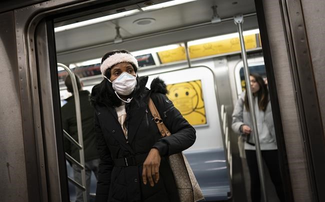 Mass transit riders wear masks as they commute in the financial district of lower Manhattan, Tuesday, April 19, 2022, in New York. U.S. District Judge Kathryn Kimball Mizelle in Tampa, Fla., on April 18, 2022, voided the national travel mask mandate as exceeding the authority of U.S. health officials. The mask mandate that covers travel on airplanes and other public transportation was recently extended by President Joe Biden's administration until May 3. (AP Photo/John Minchillo)