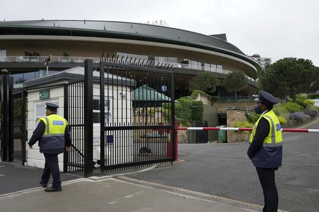FILE - Security guards work at the gates to the All England Lawn Tennis Club where preparations are underway for the Wimbledon tennis tournament in London, Friday, June 25, 2021. Tennis players from Russia and Belarus will not be allowed to play at Wimbledon this year because of the war in Ukraine, the All England Club announced Wednesday, April 20, 2022. (AP Photo/Kirsty Wigglesworth, File)