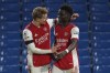 Arsenal's Bukayo Saka, right is congratulated by teammate Arsenal's Martin Odegaard after he scored his sides 4th goal from the penalty spot during the English Premier League soccer match between Chelsea and Arsenal at Stamford Bridge in London, Wednesday, April 20, 2022. (AP Photo/Frank Augstein)