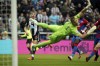 Newcastle United's Miguel Almiron, left, scores the opening goal during the English Premier League soccer match between Newcastle United and Crystal Palace at St. James' Park, Newcastle upon Tyne, England, Wednesday, April 20, 2022. (Owen Humphreys/PA via AP)