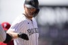 Colorado Rockies' C.J. Cron is congratulated after reaching first base on an RBI-single hit off Philadelphia Phillies starting pitcher Zach Eflin in the fifth inning of a baseball game Wednesday, April 20, 2022, in Denver. (AP Photo/David Zalubowski)
